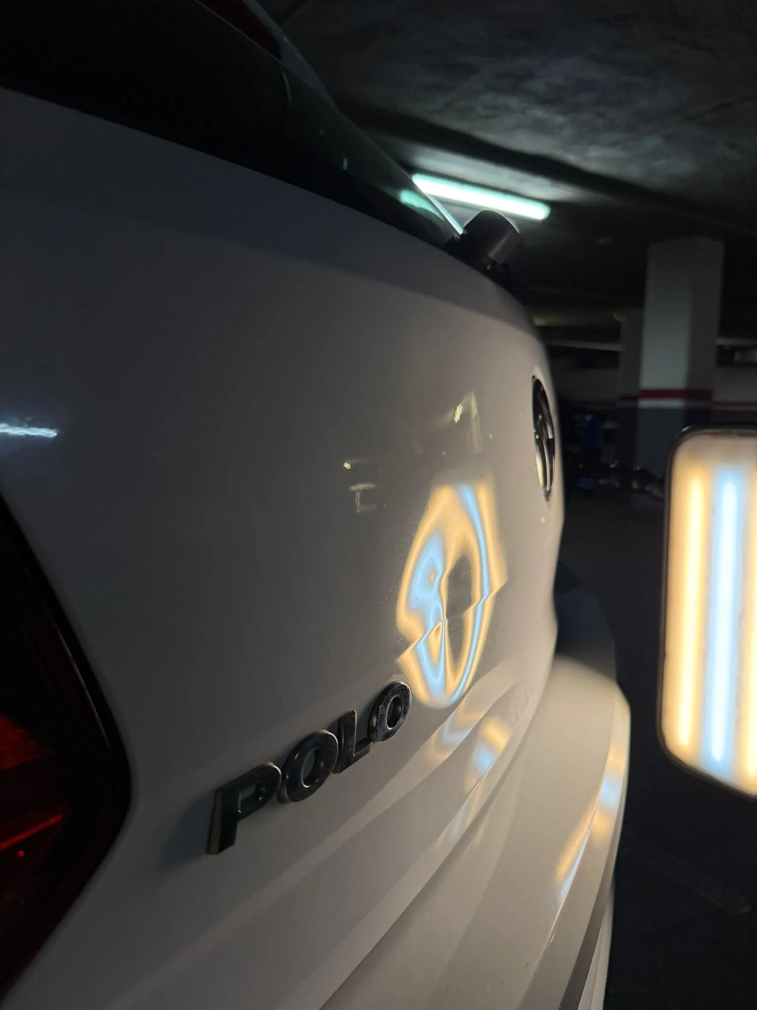 Choque mediano en el portón trasero de un VW Polo blanco visto bajo lámpara LED · PDR FR Deluxe Barcelona