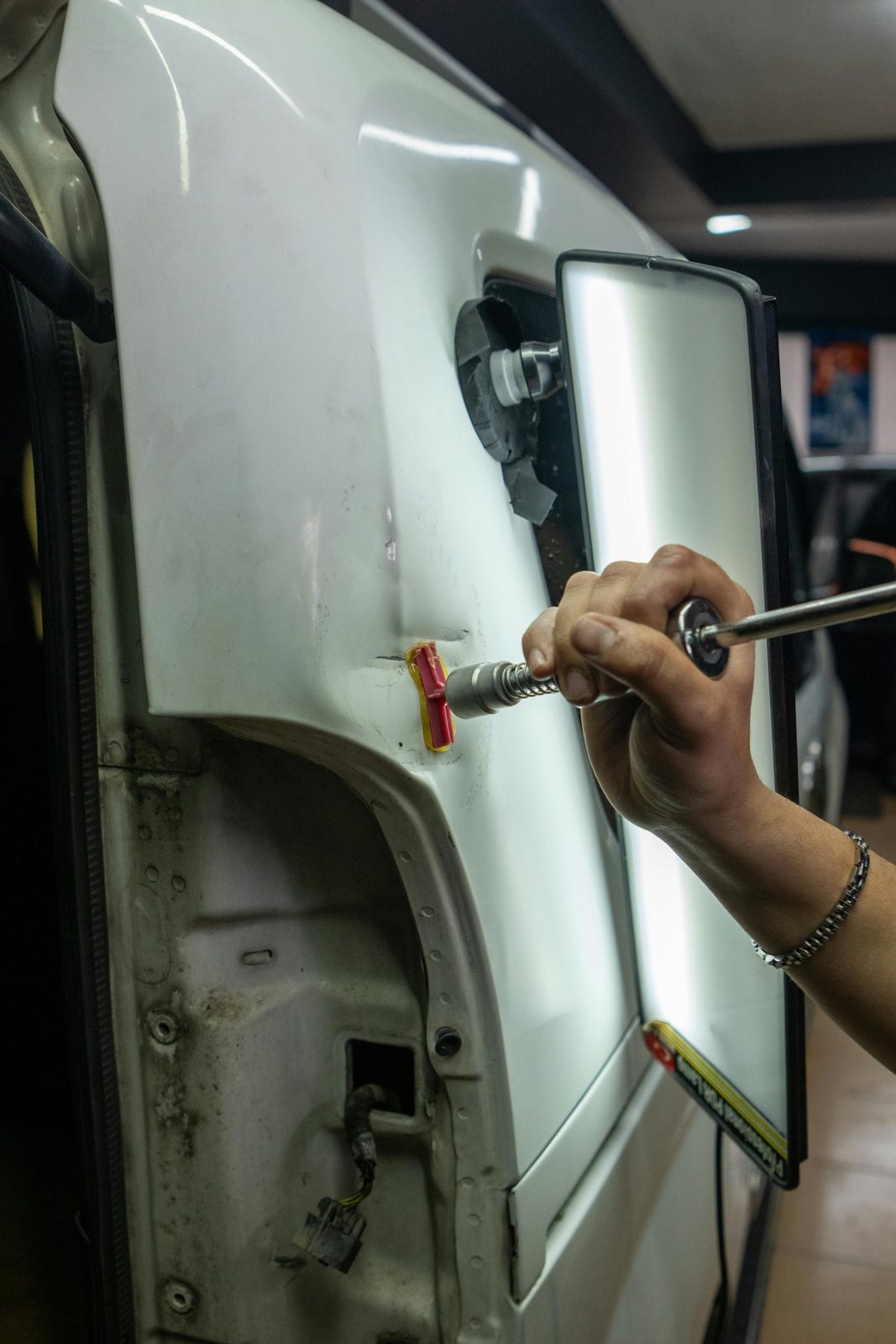 Reparación PDR de un bollo en un coche blanco con extractor en Barcelona